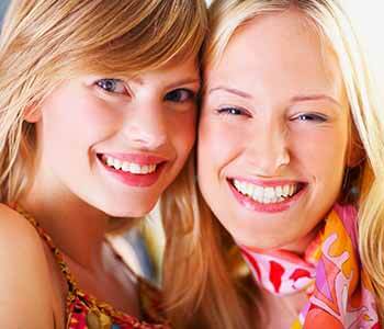 Image of a smilling young ladies showing their white teeth